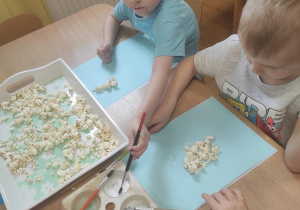 Dzieci przyklejają popcorn.