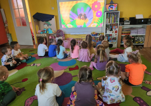 Dzieci oglądają film edukacyjny o pszczołach.