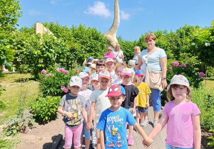 Dzieci zwiedzają park z dinozaurami.