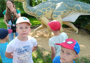 Dzieci zwiedzają park z dinozaurami.