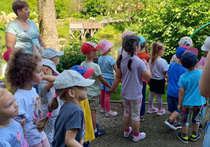 Dzieci zwiedzają park z dinozaurami.