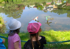 Dzieci zwiedzają park z dinozaurami.