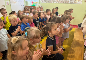 Dzieci wykonują ruchy wg instrukcji prowadzącego.