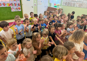 Dzieci wykonują ruchy wg instrukcji prowadzącego.