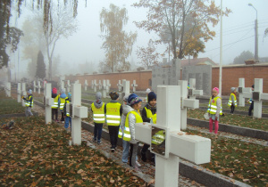 Dzieci sprzątają na grobach poległych żołnierzy