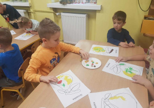 Dzieci wyklejają kontur gruszki plasteliną.