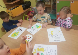 Dzieci wyklejają kontur gruszki plasteliną.