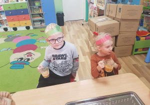 Dzieci piją zrobiony samodzielnie sok jabłkowy.