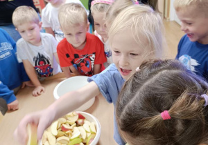 Dzieci wykonują sok przy użyciu wyciskarki.