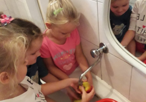 Basia, Kaja i Zuzia myją jabłka