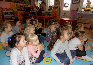 Dzieci uważnie słuchają opowiadania strażaków