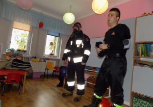 Strażacy prezentują strój wykorzystywany podczas gaszenia pożarów
