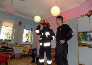 Strażacy prezentują strój wykorzystywany podczas gaszenia pożarów