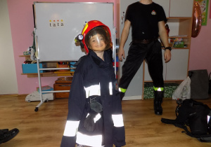 Marta w kurtce i hełmie strażaka
