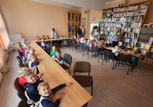 Dzieci słuchają bajki o Misiu czytanej przez Panią Bibliotekarkę.