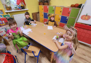 Dzieci układały puzzle papierowe i przyklejały je na kartkę.