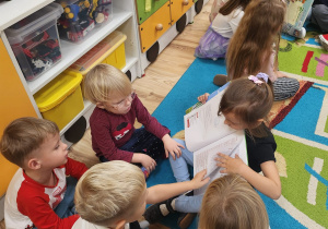 Dzieci wspólnie oglądają ksiązki.