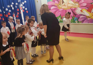 Pani Dyrektor wręcza dzieciom dyplom za udział w Przeglądzie Pieśni Patriotycznych.