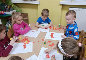 Dzieci wykonują flagę Polski techniką wydzieranki.