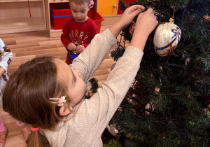 Dzieci ubierają choinkę pola