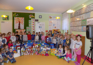 Dzieci prezentują efekty zbiórki: karmę, koce, zabawki, itd.