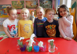 Nadia, Lilianka, Marysia, Filip i Marta prezentują swoje kwiatki w kolorowej wodzie.