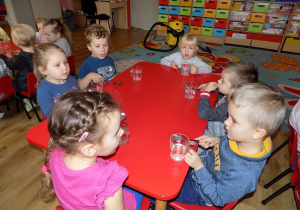 Marysia, Eryk, Lilianka, Marcel, Filip i Lenka przy pomocy łyżek grają na szklankach.