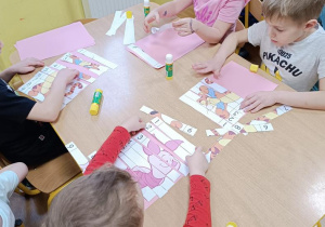 Dzieci układają puzzle "Kubuś Puchatek i przyjaciele" z 9 części. .