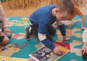 Dzieci układają puzzle i utrwalają nazwy planet wchodzące w skład Układu Słonecznego.
