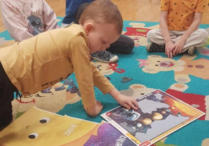 Dzieci układają puzzle i utrwalają nazwy planet wchodzące w skład Układu Słonecznego.