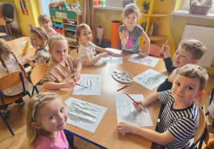 Dzieci malują swoje maski za pomocą farb.