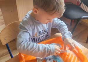 Jeremi nakleja piórka do swojej maski.