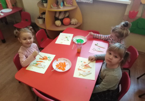Luiza, Zosia i Ola malują marchewki wykonane z masy solnej