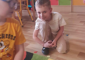 Dzieci układają kompozycje kwiatowe z mozaiki geometrycznej.