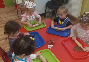 Lila, Hania, Roksana, Olek i Oliwka rozwałkowują masę piernikową.