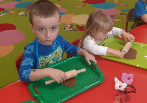 Adam i Amelia rozwałkowują masę piernikową.