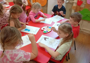 Dzieci stemplują portret mamy.
