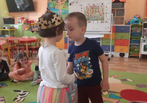 Lilianka częstuje Adasia urodzinowymi słodkościami.