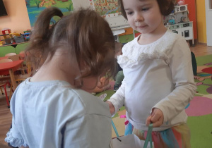 Lilianka częstuje Hanię urodzinowymi słodkościami.