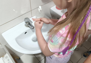Oliwia zmywa stempelek.