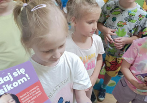 Dzieci otrzymują broszurki informacyjne.