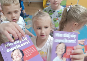 Dzieci otrzymują broszurki informacyjne.