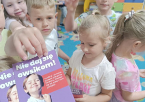 Dzieci otrzymują broszurki informacyjne.