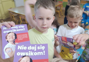 Dzieci otrzymują broszurki informacyjne.