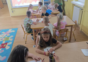 Dzieci kolorują obrazki.