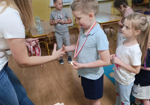 Pani wręcza dzieciom medale.