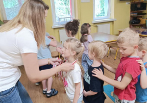Pani wręcza dzieciom medale.
