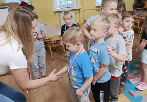 Pani wręcza dzieciom medale.