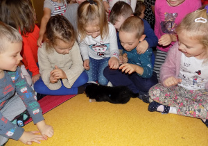 Dzieci z grupy "Jaskółki" witają się ze szczeniaczkiem