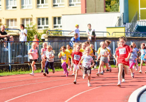 Dzieci uczestniczą w biegu przedszkolaka.